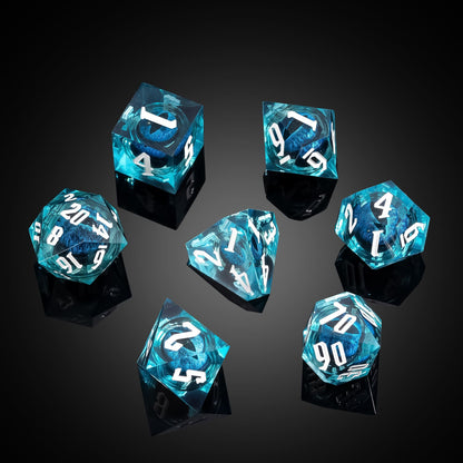 Dragon Eye Blue sharp edge dice set scattered on black surface showing clear teal resin and blue core