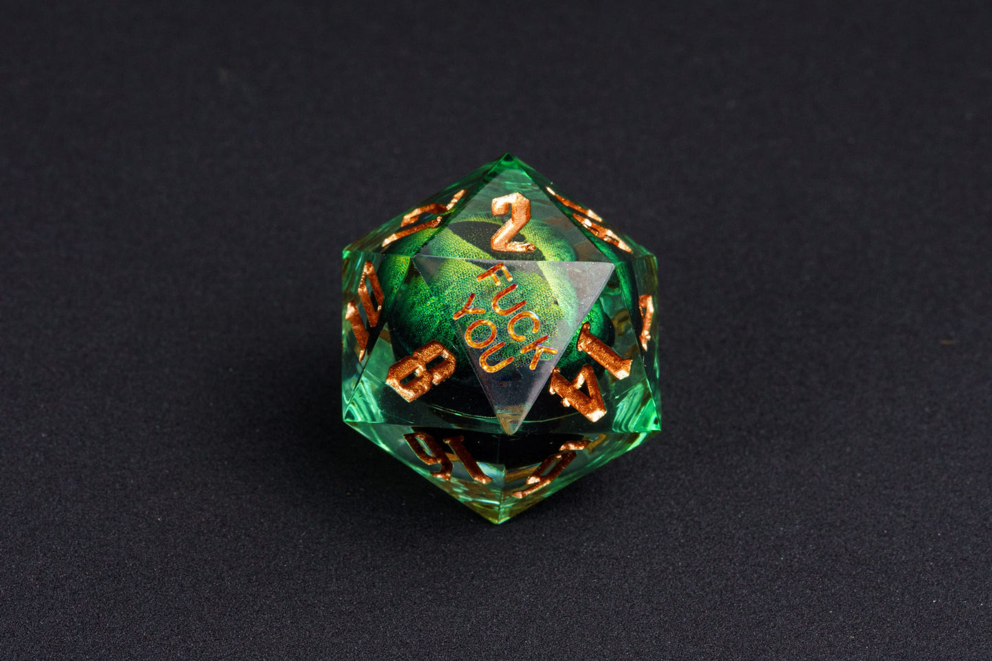 Close-up of Dragon Eye Green Yeet Sharp Edge D20 die showing Yeet face with emerald eye design