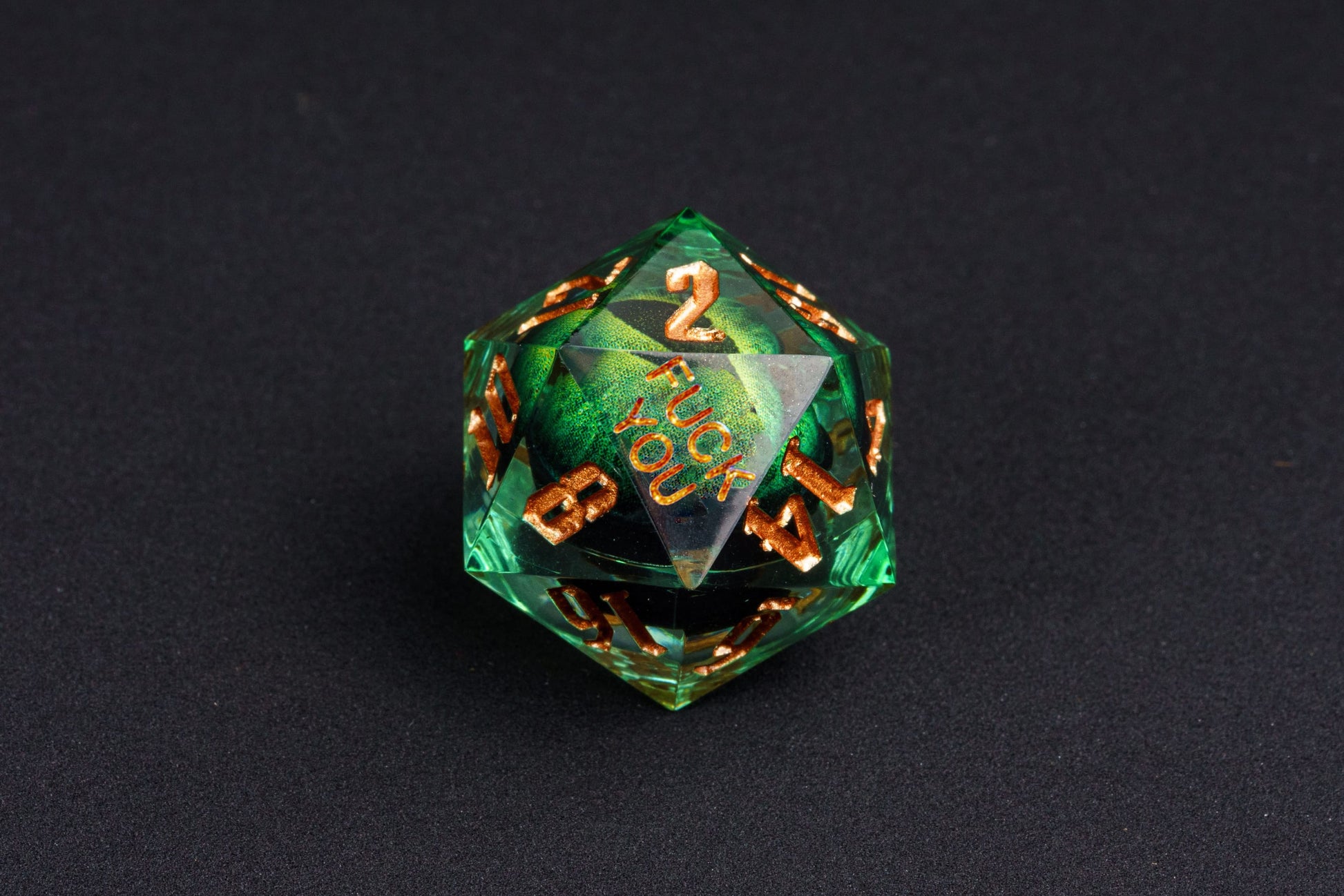 Close-up of Dragon Eye Green Yeet Sharp Edge D20 die showing Yeet face with emerald eye design