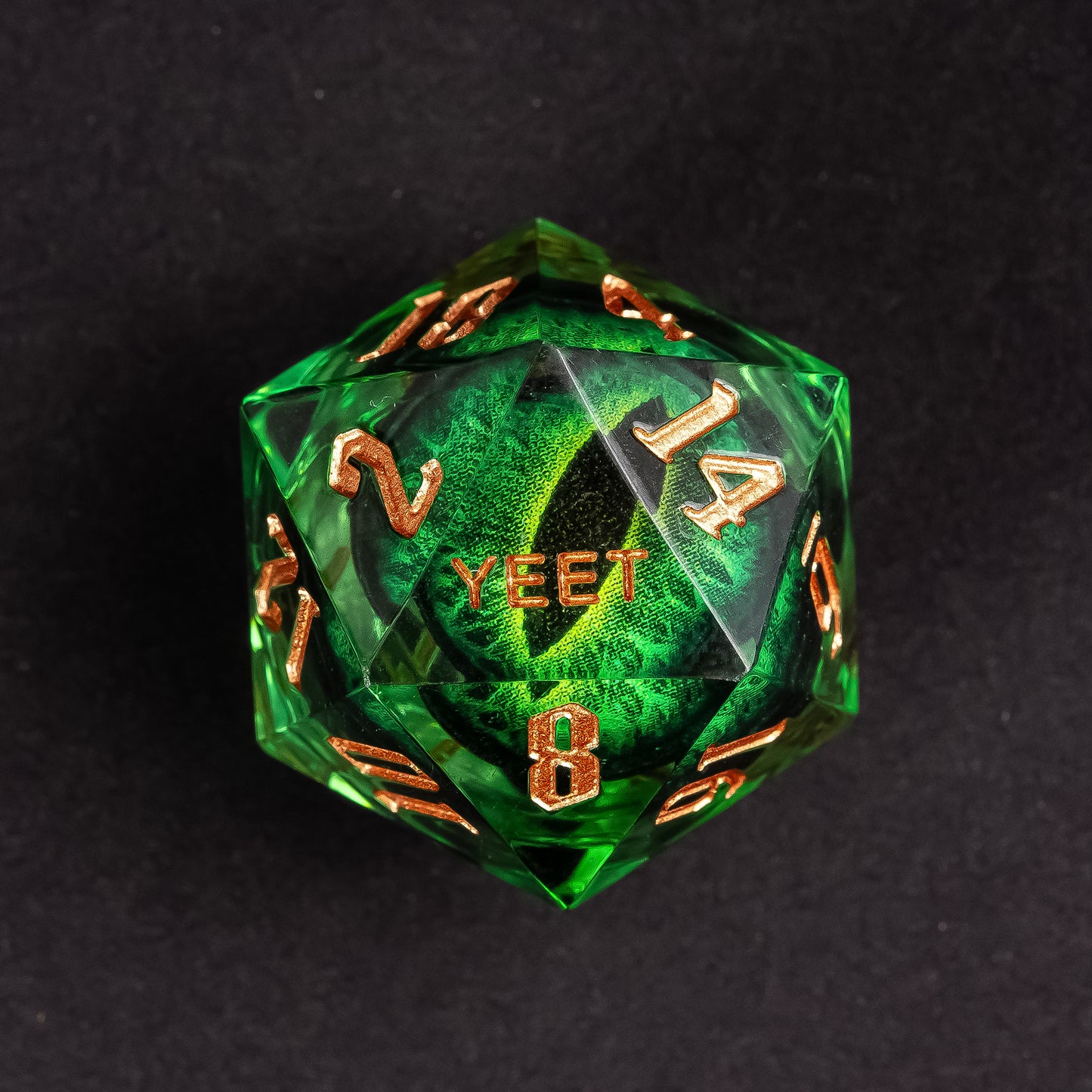 Close-up of Dragon Eye Green Yeet Sharp Edge D20 die showing Yeet face with emerald eye design