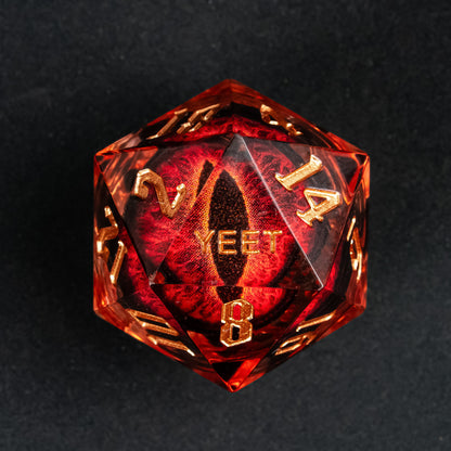 Close-up of the D20 from Dragon Eye (Red) Yeet Sharp Edge Dice Set showing gold numbering and embedded red eye design