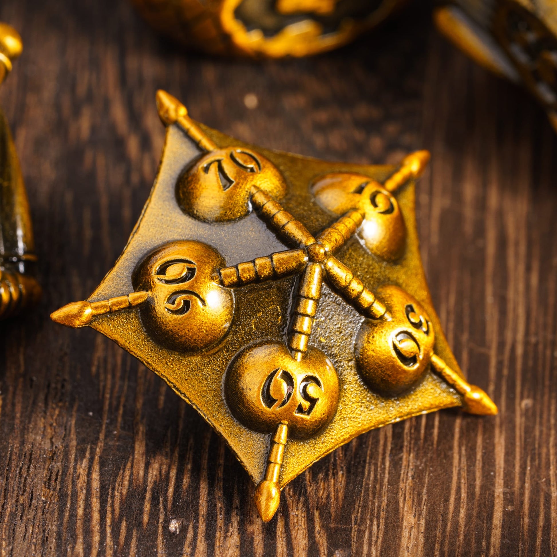 Close-up of d10 die from Eldritch Edge Metal Dice Collection Ancient Gold variant, intricate design
