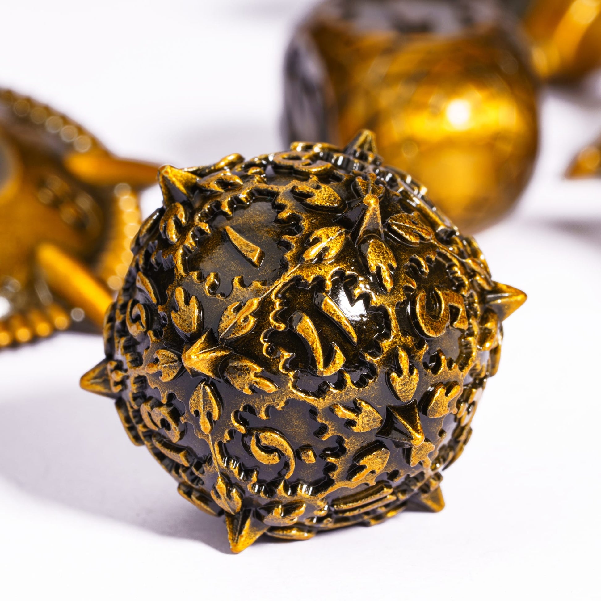 Detailed d100 die from Eldritch Edge Metal Dice Collection Ancient Gold with ornate engraved design