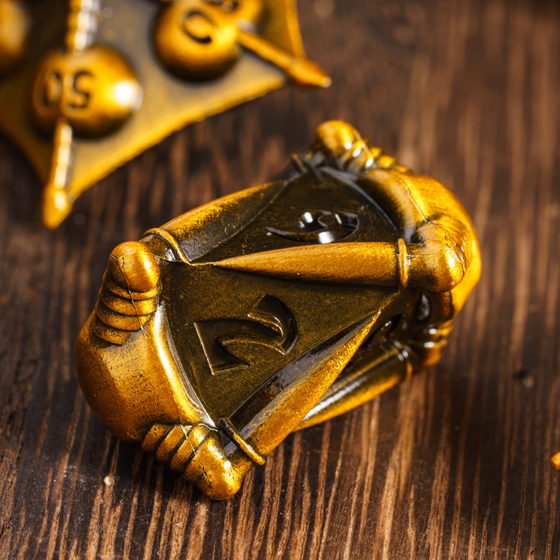 Elongated d8 die from Eldritch Edge Metal Dice Collection Ancient Gold with ornate gothic details