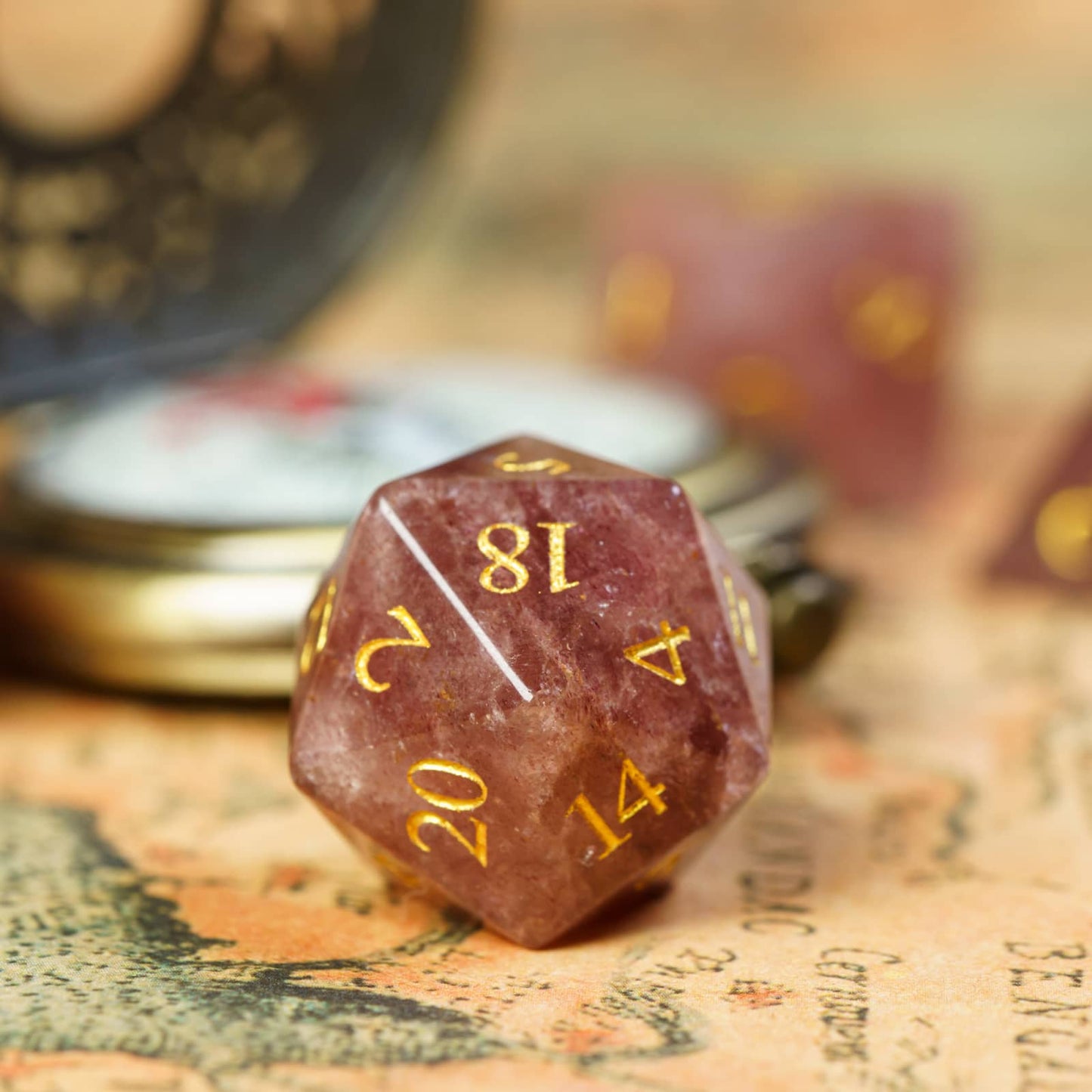 Single D20 from Ember Rose stone dice set showing golden engraved numbers, part of Fabled Crystals Stone Dice Series