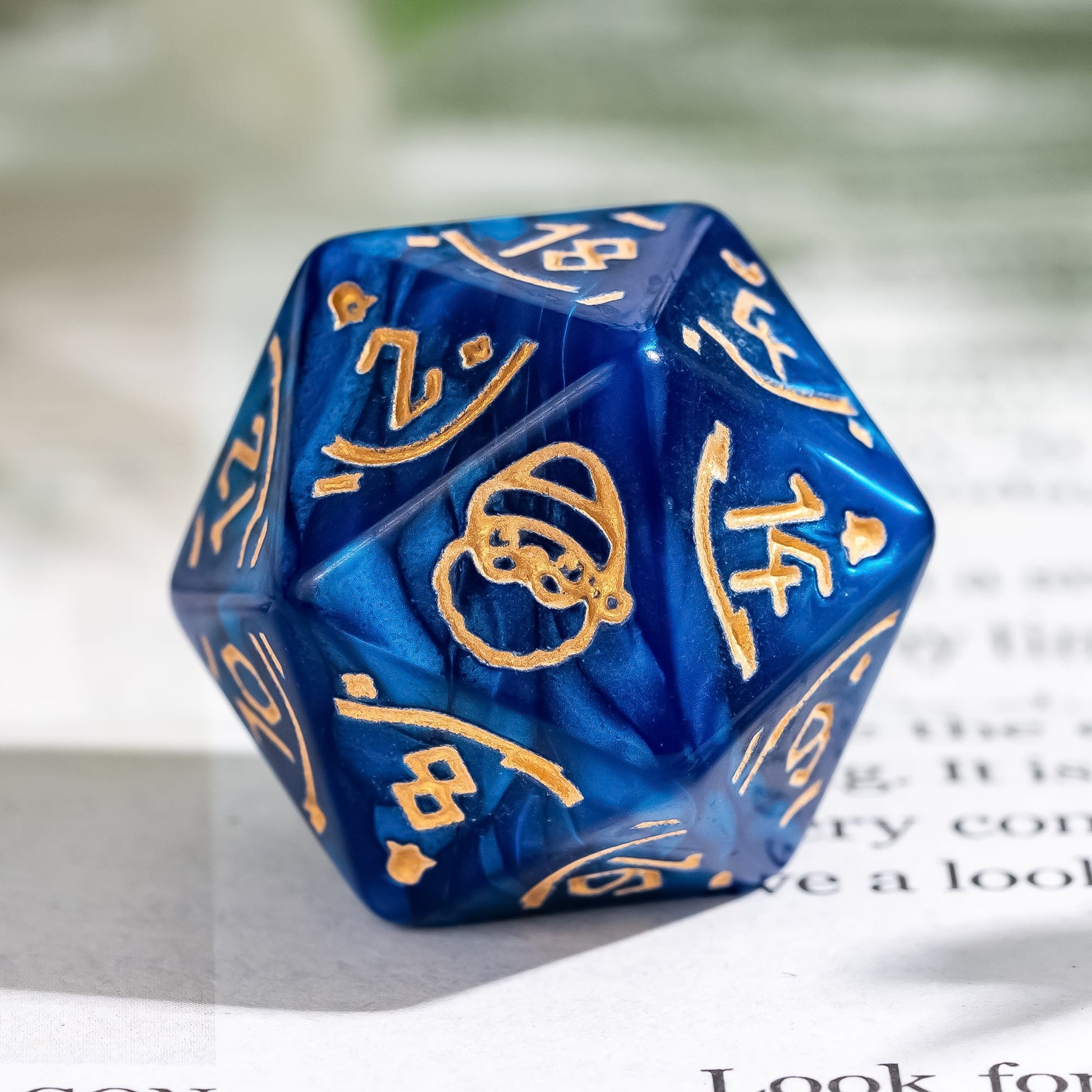 Macro shot of blue Festive Fate D20 dice featuring Santa engraving and gold ink for DnD Christmas campaigns
