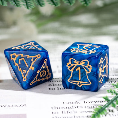 Close up of blue Festive Fate holiday D6 and D8 dice with gold bell and Christmas tree engravings