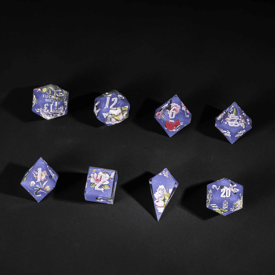 Flat lay of Floral Eclipse Sharp Edge Dice Set with floral art for DnD sessions