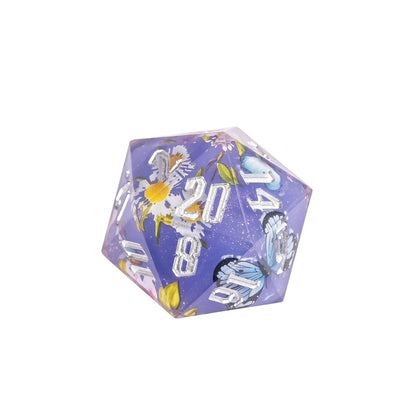 Close up of Floral Eclipse Sharp Edge D20 showing floral artwork and white engraved numbers in translucent violet resin