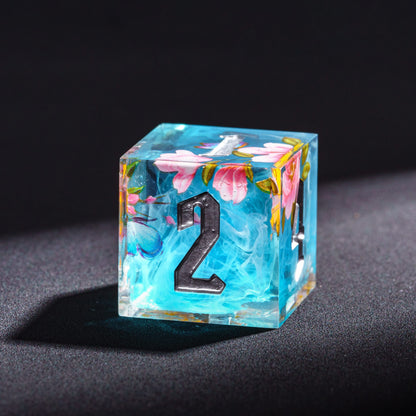 Close-up of Floral Mist Sharp Edge D6 die with flowers & butterfly, part of 7 piece resin dice set for DnD