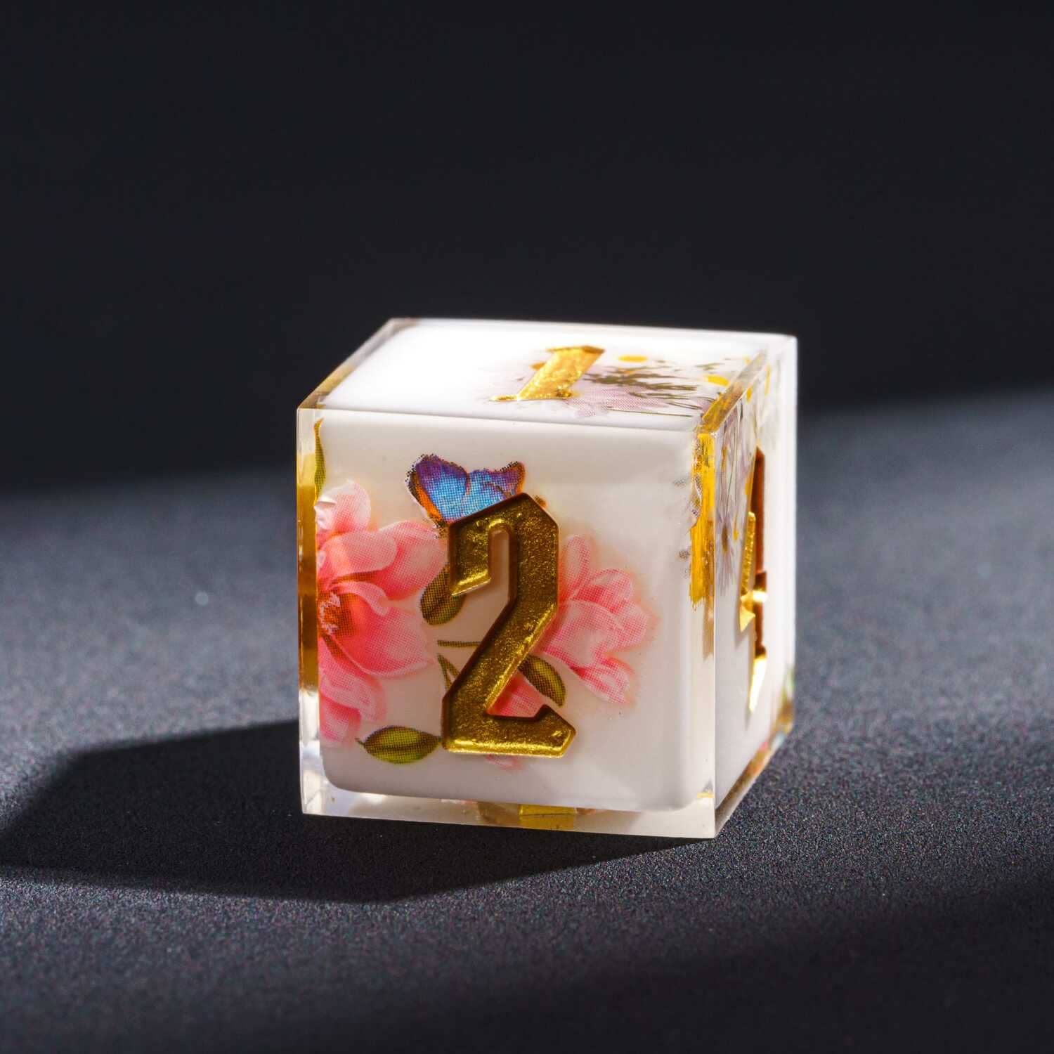 Macro close up of Floral Radiance Sharp Edge D6 featuring pink floral design and metallic gold number engraving