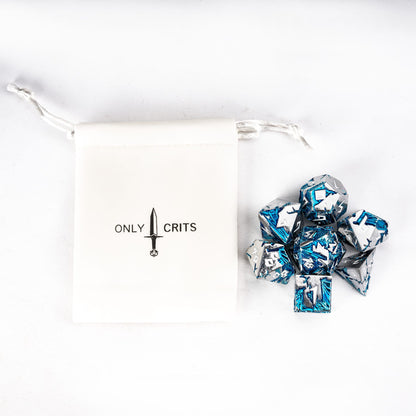 Flat lay of Frost Tide Dragon metal dice set with blue tide detailing and Only Crits dice pouch