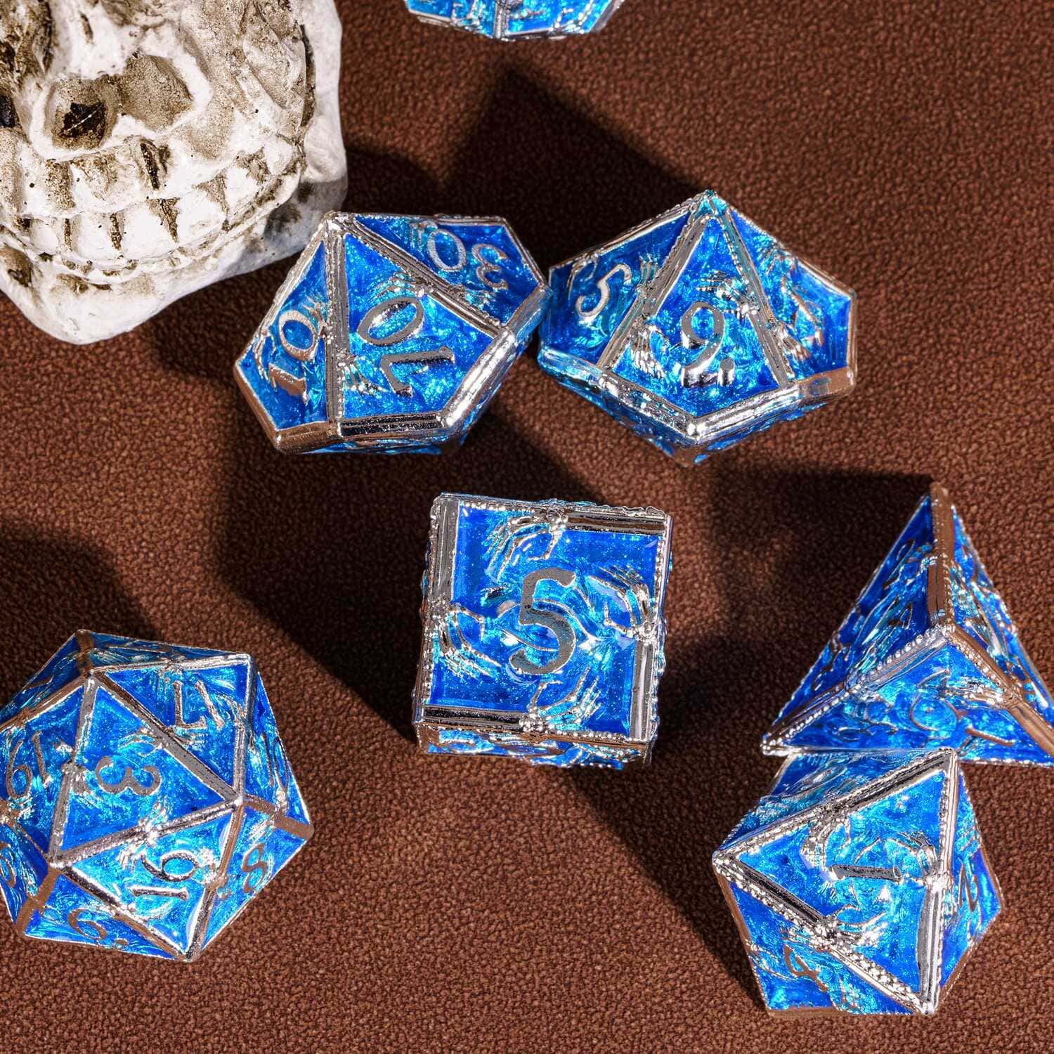 Frosted Crypt Metal Dice Set flat lay of RPG dice with skull prop background