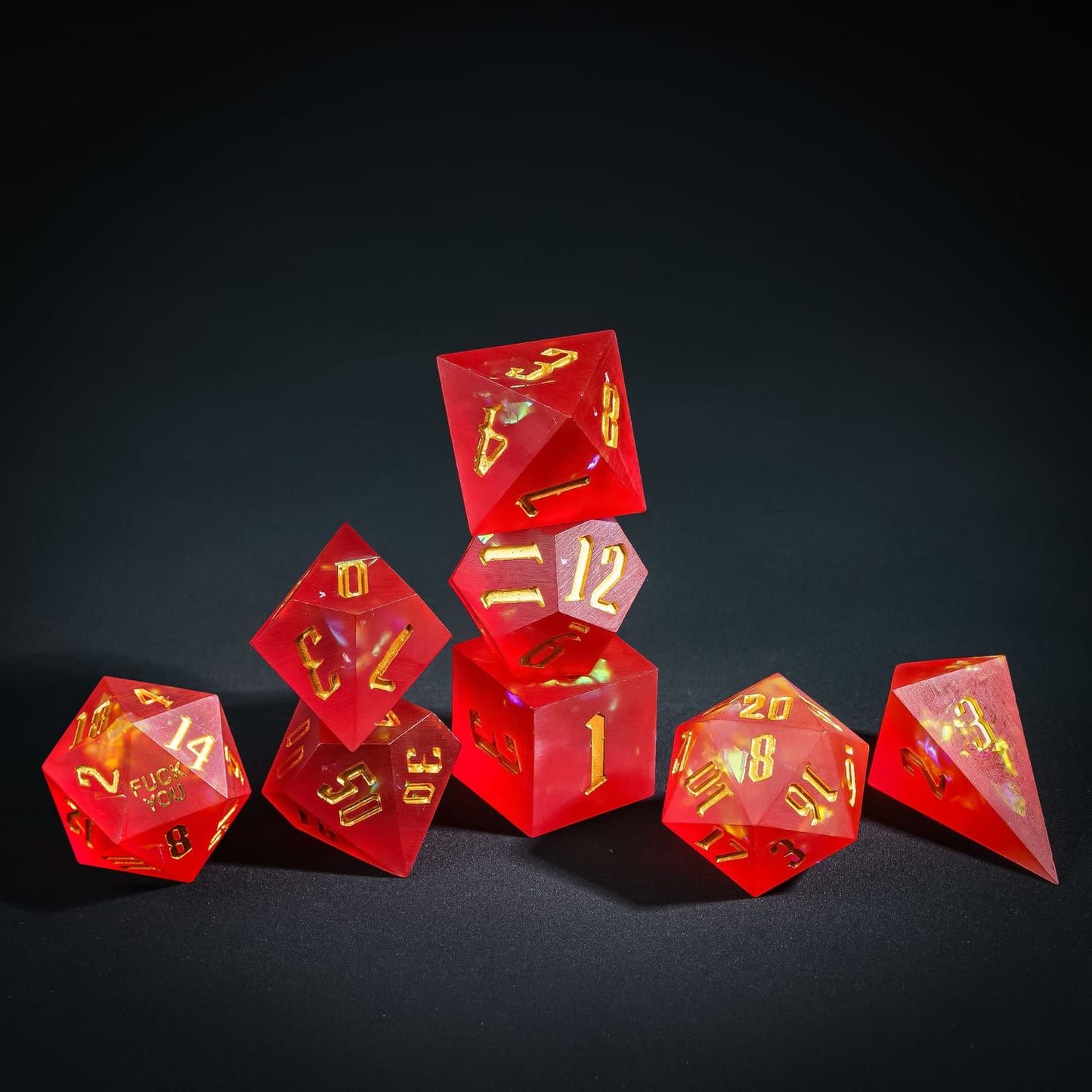 Stacked display of Frosted Ember Fuck You Sharp Edge Dice Set for DnD collectors