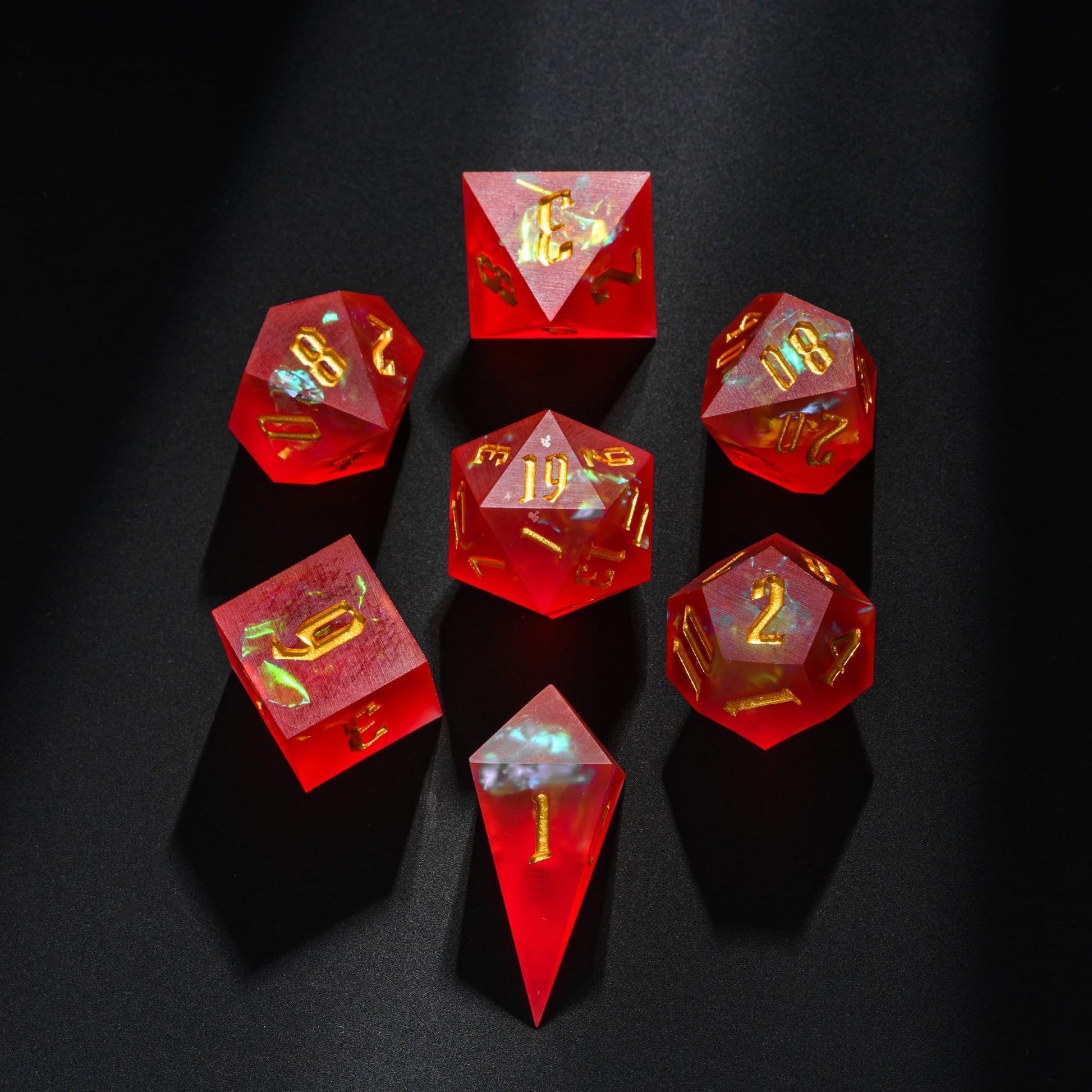 Frosted Ember sharp edge resin 7-piece dice set displayed on dark background with gold numbering and ember-like inclusions.