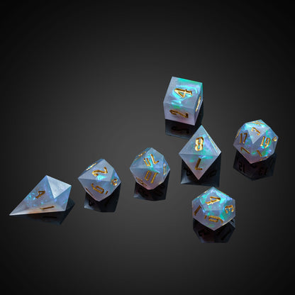 Frosted Mirage Sharp Edge Dice Set arranged on dark background highlighting glowing blue resin core
