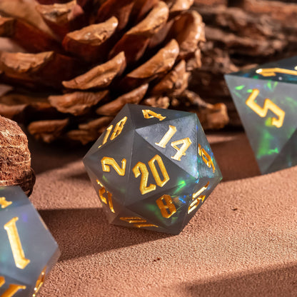 Frosted Mirage sharp edge D20 with gold numbering and green shimmer inclusions beside pinecone