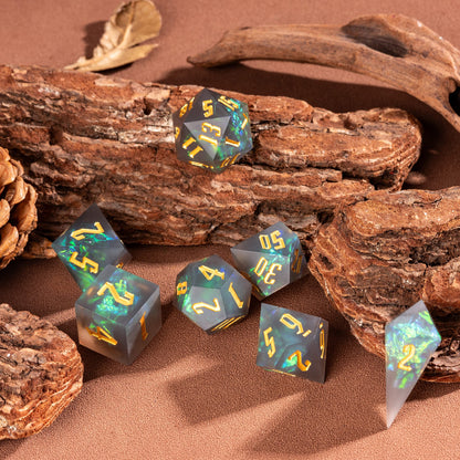 Flat lay of Frosted Mirage sharp edge 7 piece dice set with frosted resin and green iridescent inclusions