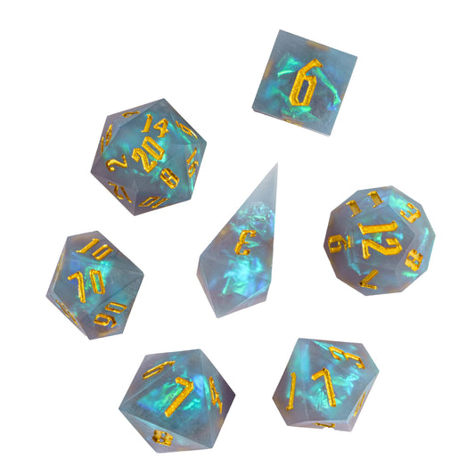 Flat lay of Frosted Mirage Sharp Edge Dice Set with icy blue resin & golden numbers for DnD RPG