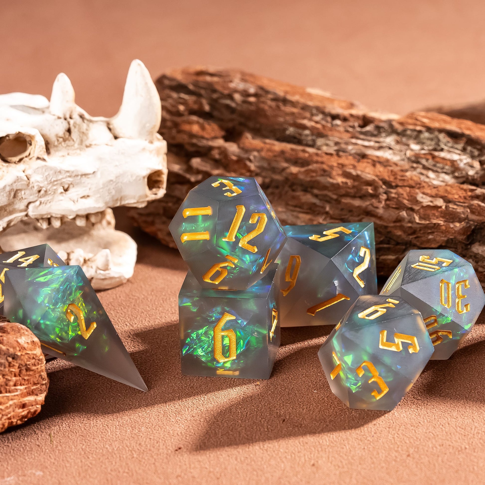 Frosted Mirage sharp edge dice set with frosted resin and green iridescent inclusions displayed on wood