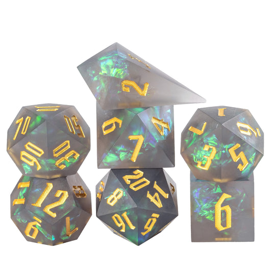 Frosted Mirage sharp edge dice set stacked in smoky grey resin with green shimmer and gold numbers