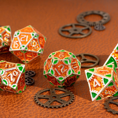 Close-up of the Guillman's Guilded Metal Dice Set D12 featuring orange translucent resin, silver metal framework, green accents, and detailed engraved numbering