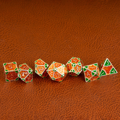 Guillman's Guilded Metal Dice Set arranged in a row on a brown leather surface, displaying all seven polyhedral dice