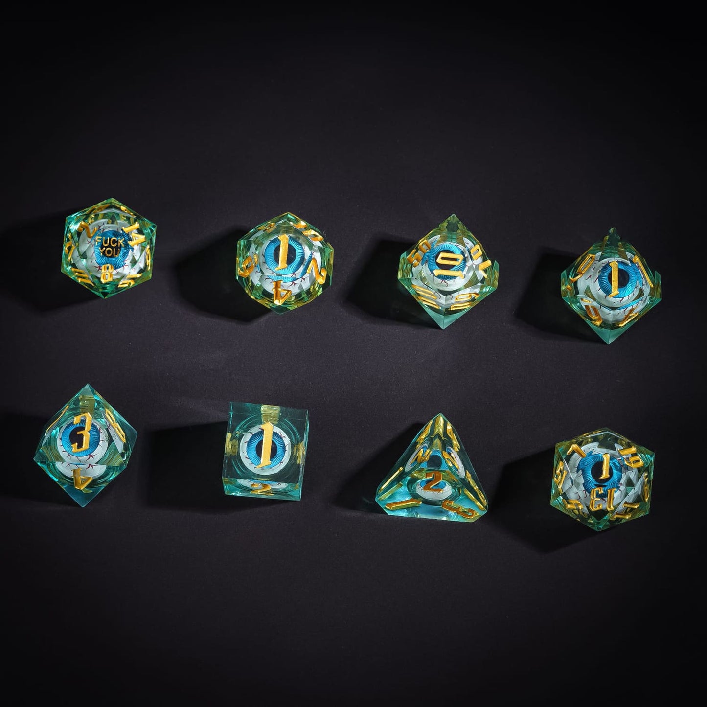 Flat lay of Liquid Core Eye Blue Sharp Edge Dice Set with eyeball core design for DnD