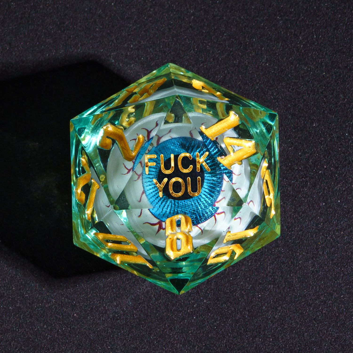 Close up of Liquid Core Eye Blue Fuck You D20 Sharp Edge Die with gold numbers for DnD