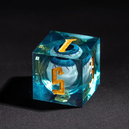 Close up of Liquid Core Eye Blue Sharp Edge D6 showing floating blue liquid eye core and gold numbering