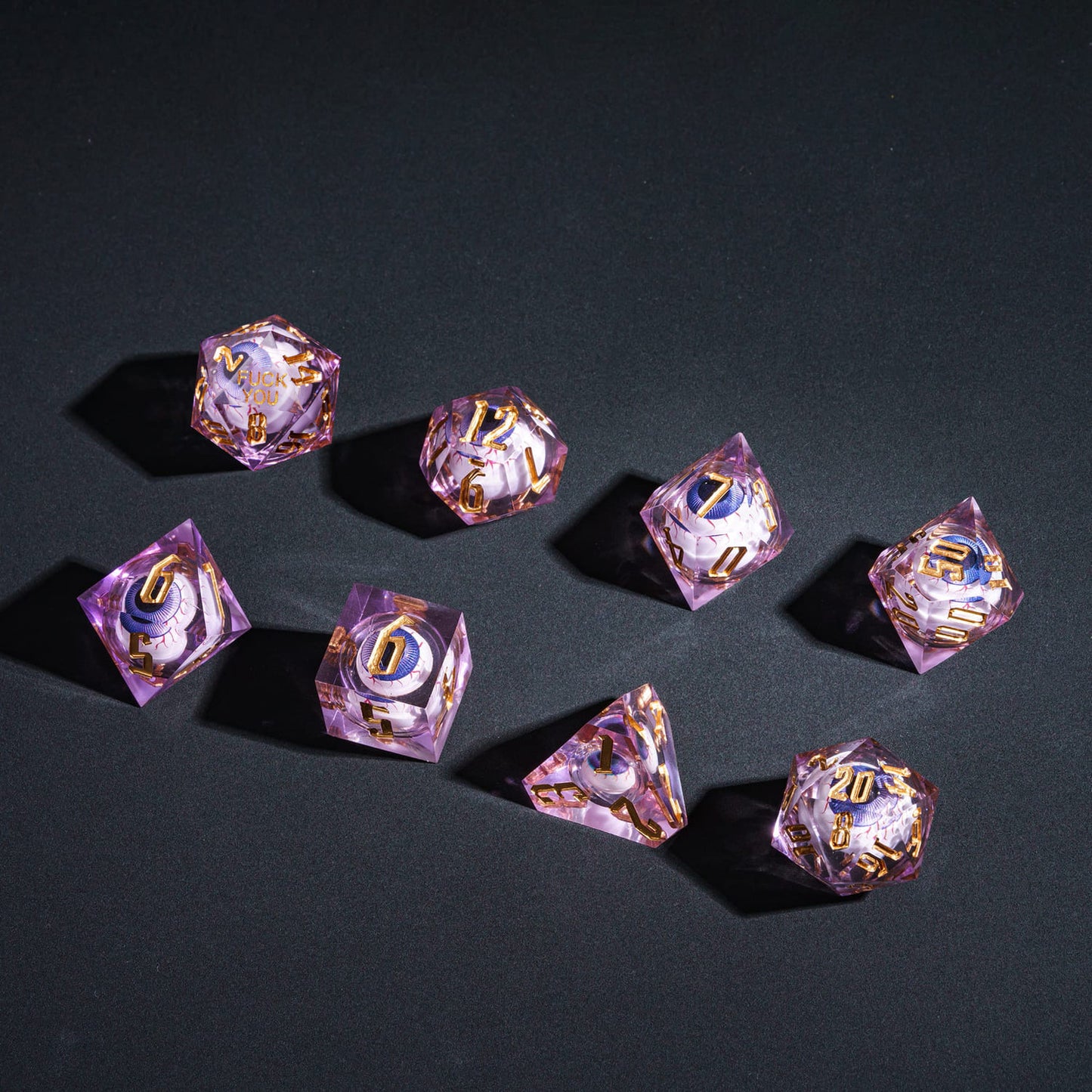 Flat layout of purple Liquid Core Eyeball Sharp Edge Dice Set showing all 7 dice for DnD & TTRPG