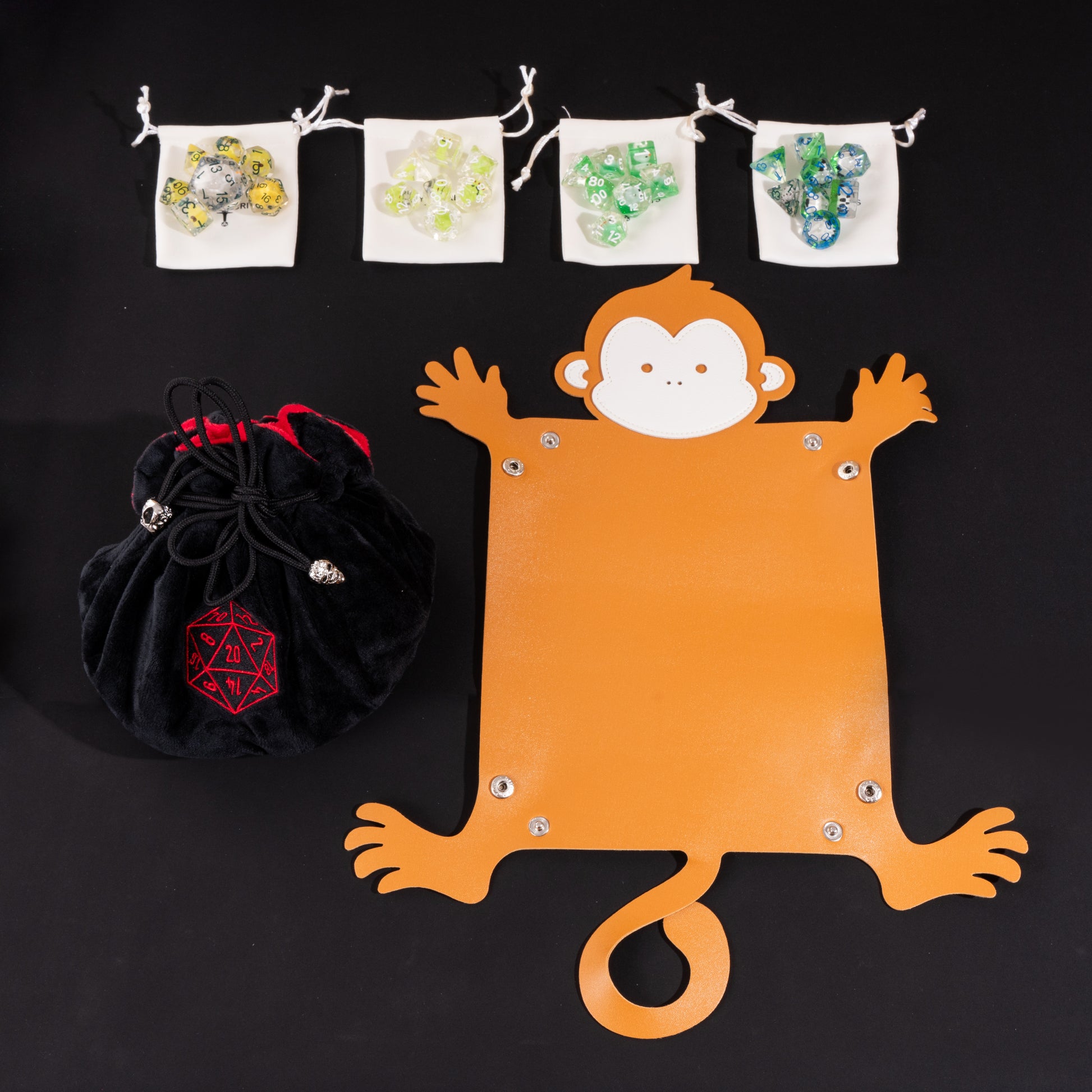 Little Friends Dice Bundle with a monkey-shaped dice tray holding multiple polyhedral dice alongside a premium black velvet dice bag