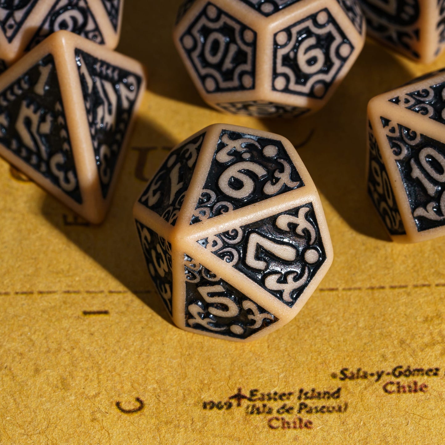 Close-up of brown Medieval Majesty d10 with black engravings, displayed on parchment