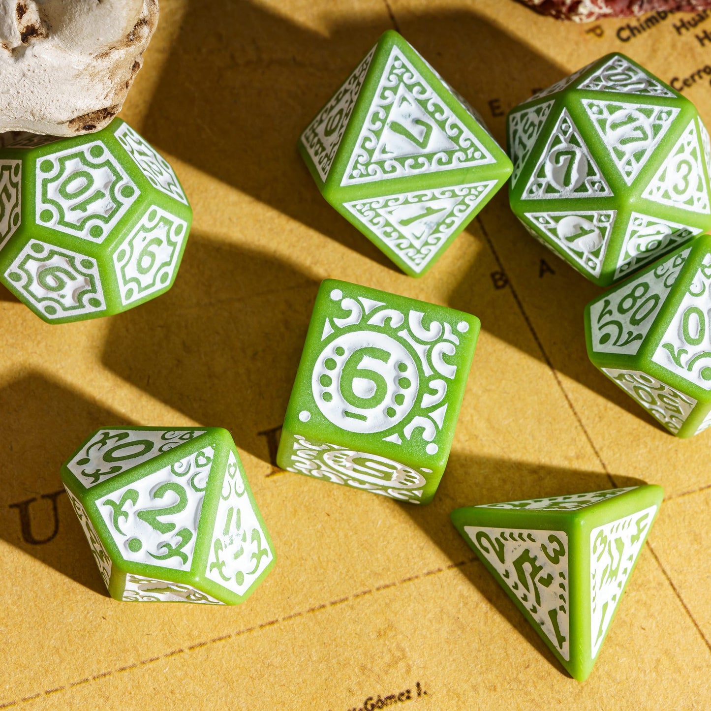 Green Medieval Majesty dice spread out on a map background, featuring decorative carvings