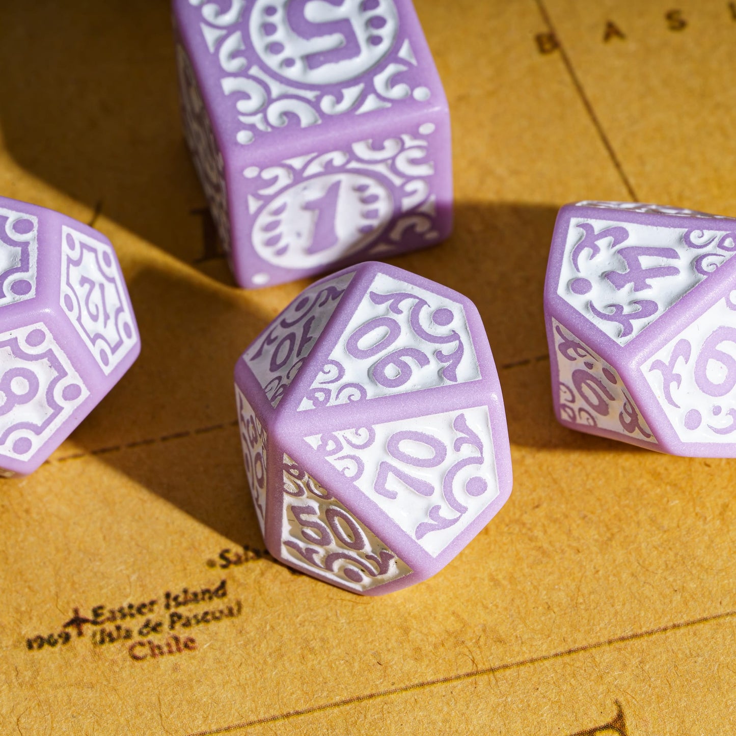 Purple Medieval Majesty dice arranged on parchment with intricate carvings