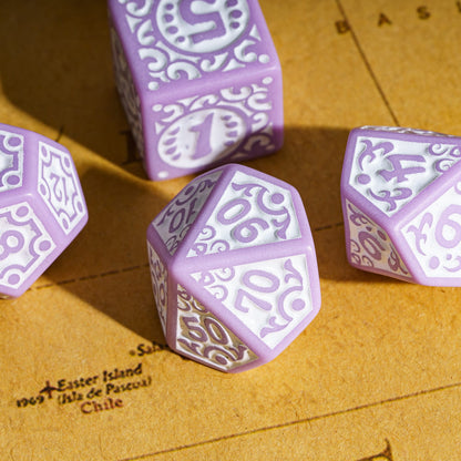 Purple Medieval Majesty dice arranged on parchment with intricate carvings