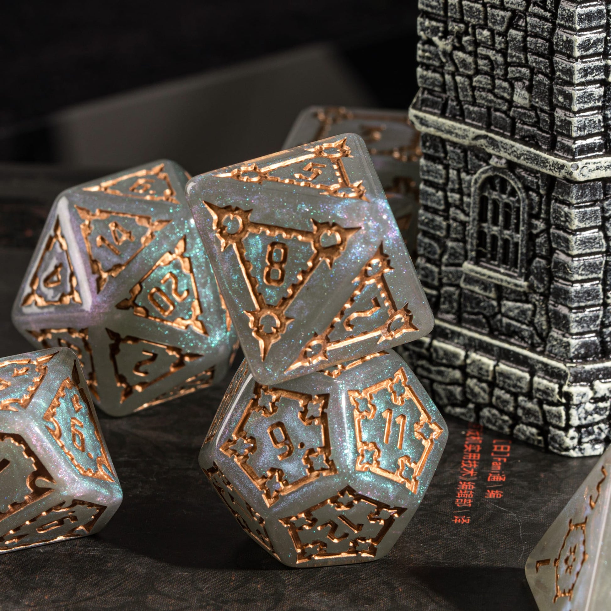 Moonlight Elixir Chonk D8 and D12 displayed beside castle terrain with shimmering teal highlights