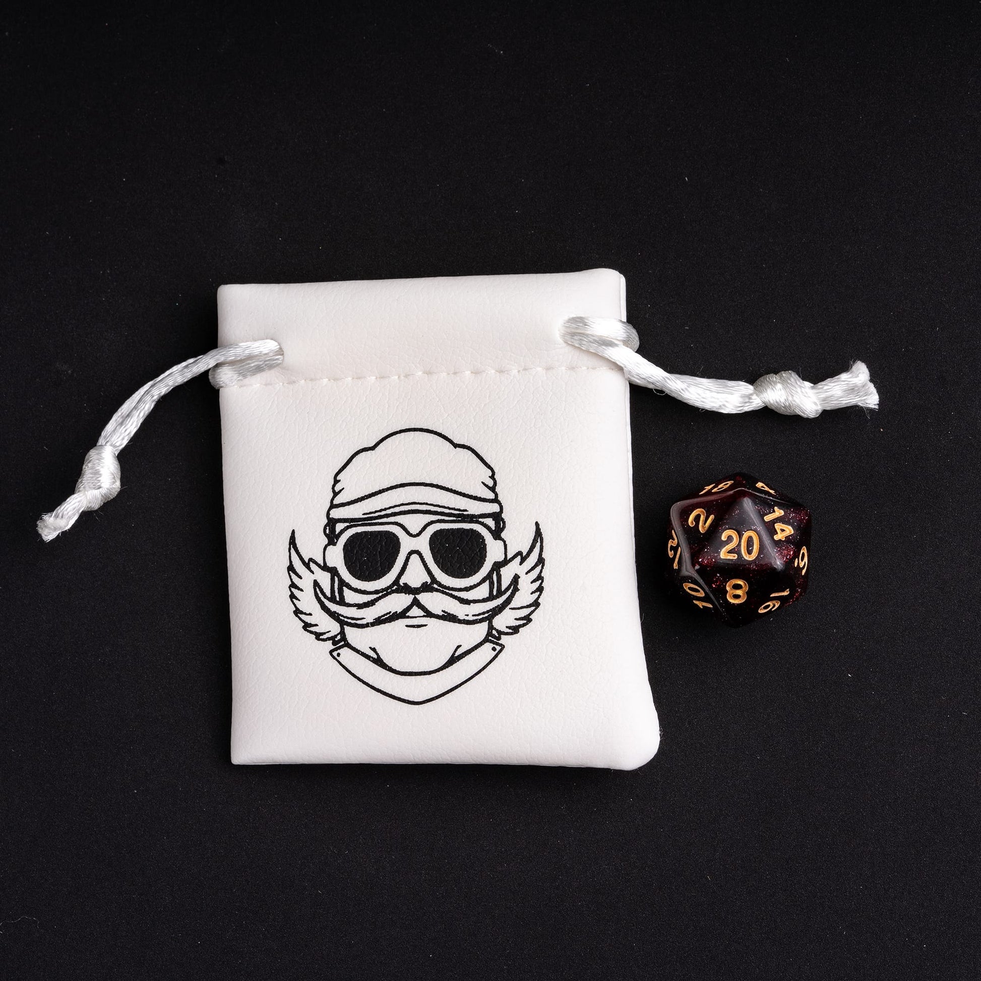 Black and gold glitter D20 die beside Only Crits dice pouch
