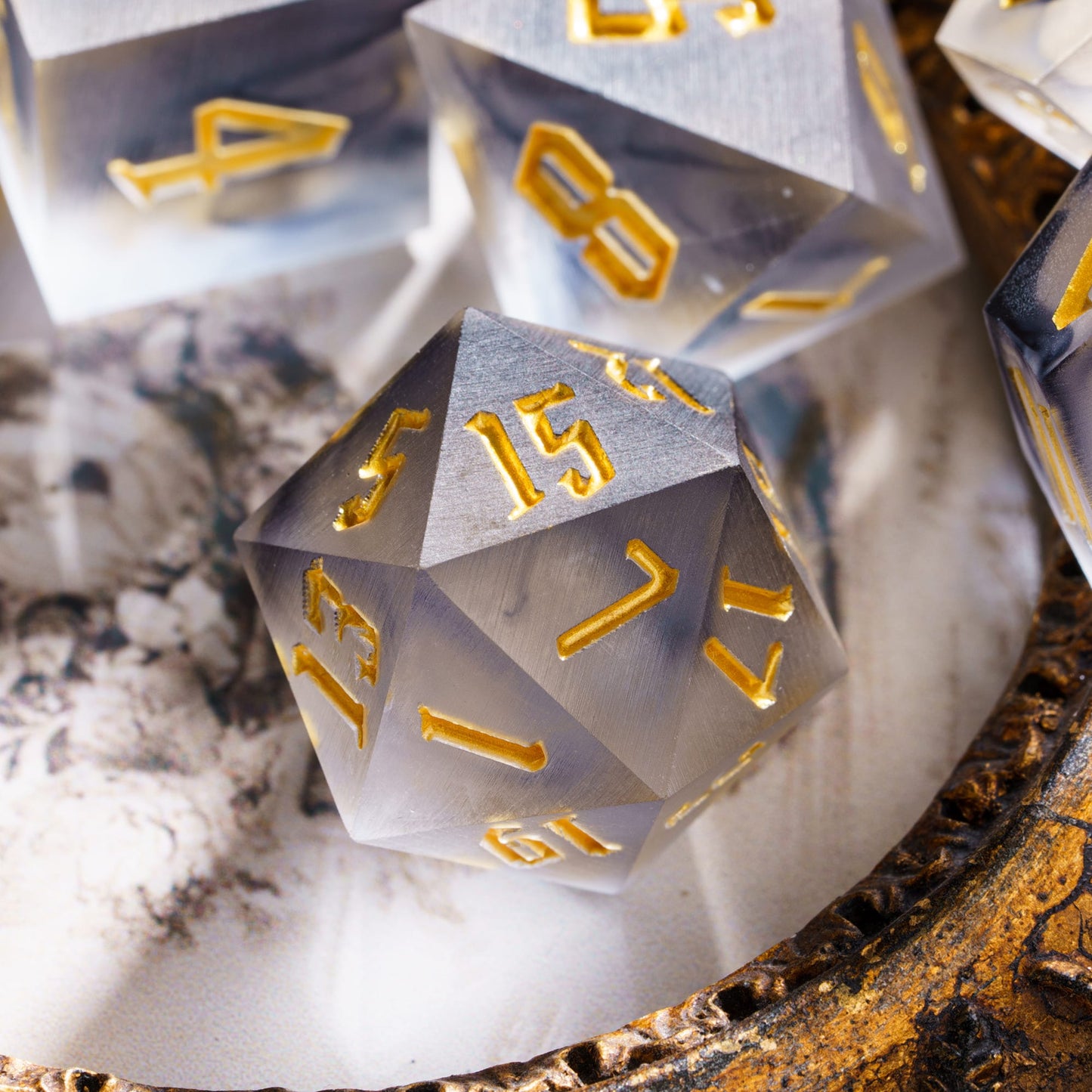 Nimbus Noir Sharp Edge D20 resting on ornate tray with smoky resin design and gold numbering for DnD & DnD 5e