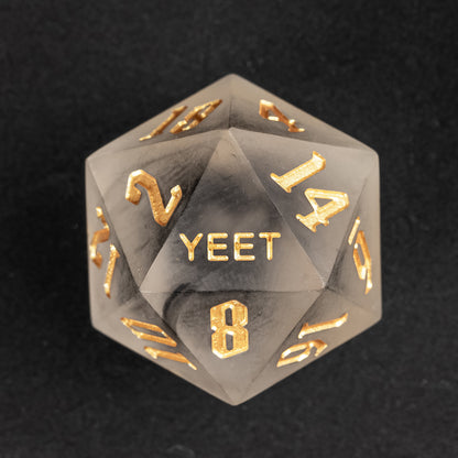 Close-up of Nimbus Noir Yeet Me sharp edge D20 with black smoke resin and gold numbers