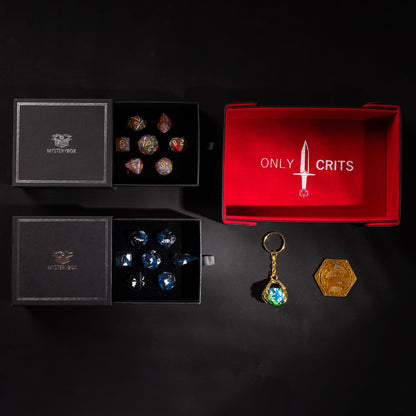 Deluxe Mystery Box example: two dice sets in mystery boxes with an Only Crits magnetic dice tray, keychain and coin