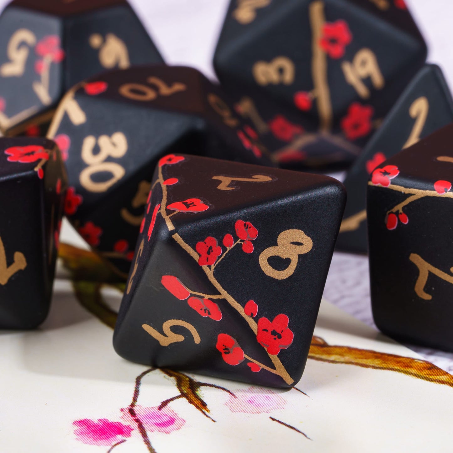 Closeup of Sakura Blossom black and red 7 piece dice set for DnD