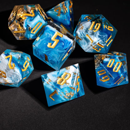 Angled close up of Shimmering Shoals sharp edge dice showing blue swirls and gold foil accents