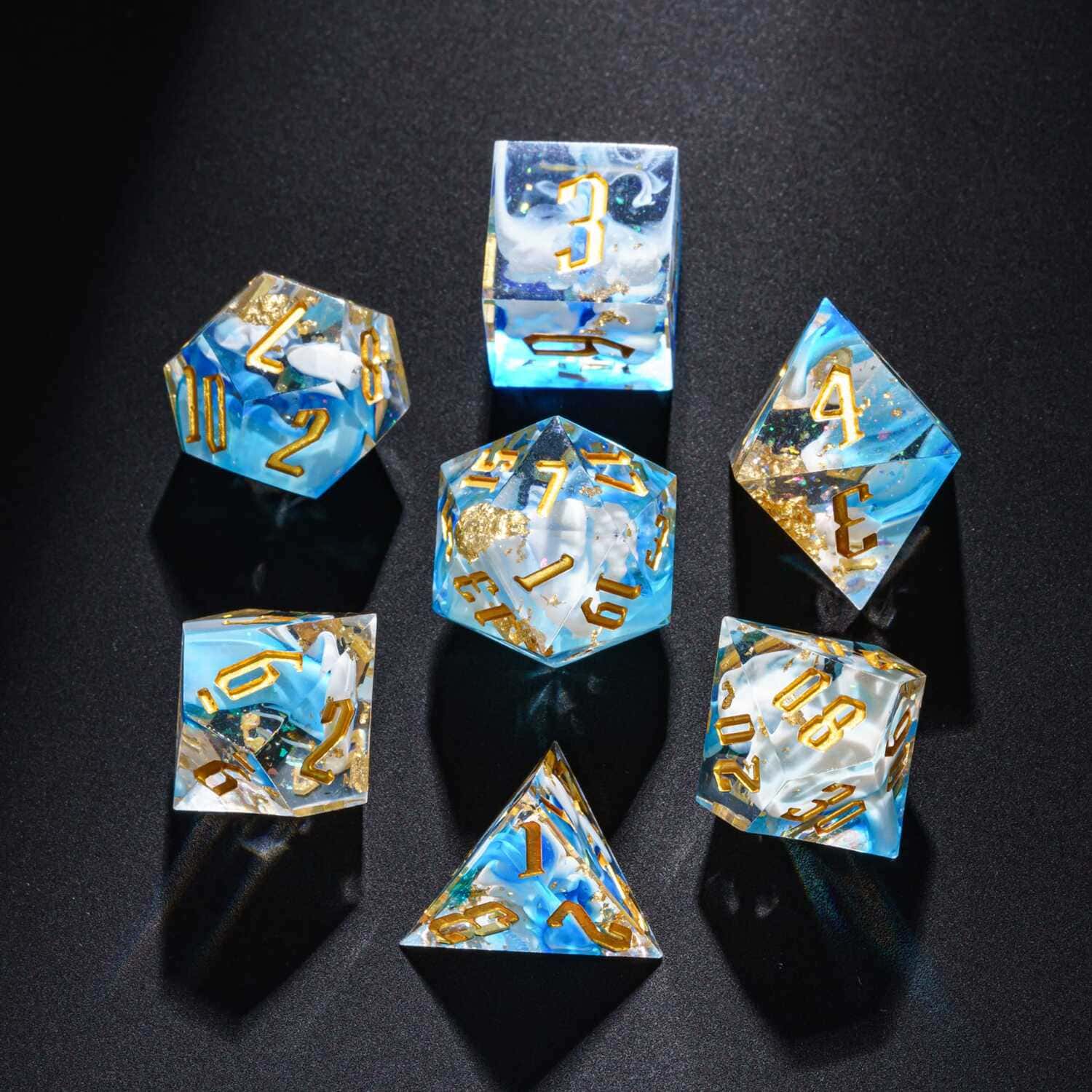 Top view of Shimmering Shoals resin dice set with blue ocean swirls and gold foil flakes