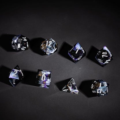 Flat lay of Siren's Cache Sharp Edge Dice Set with black purple resin for DnD