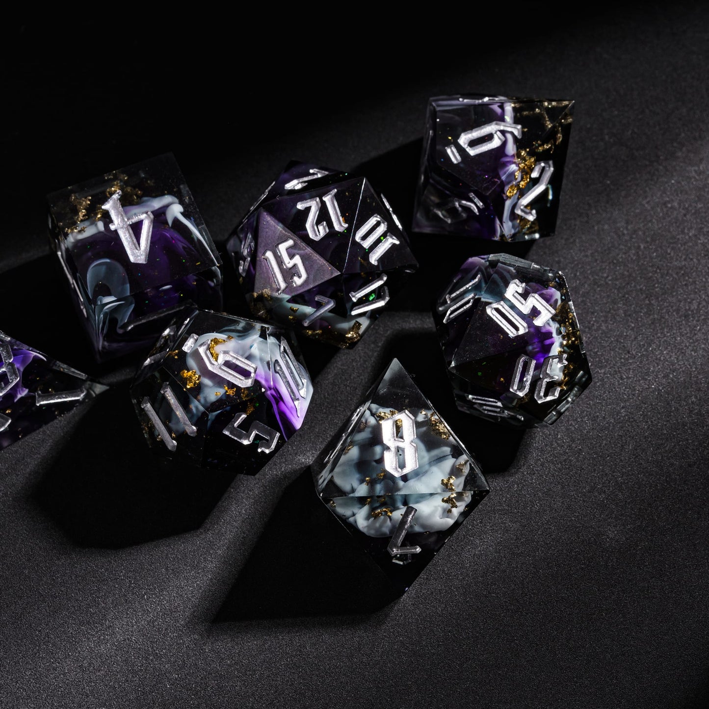 Siren’s Cache sharp edge DnD dice set on black surface with dark resin, purple swirls, and gold foil accents