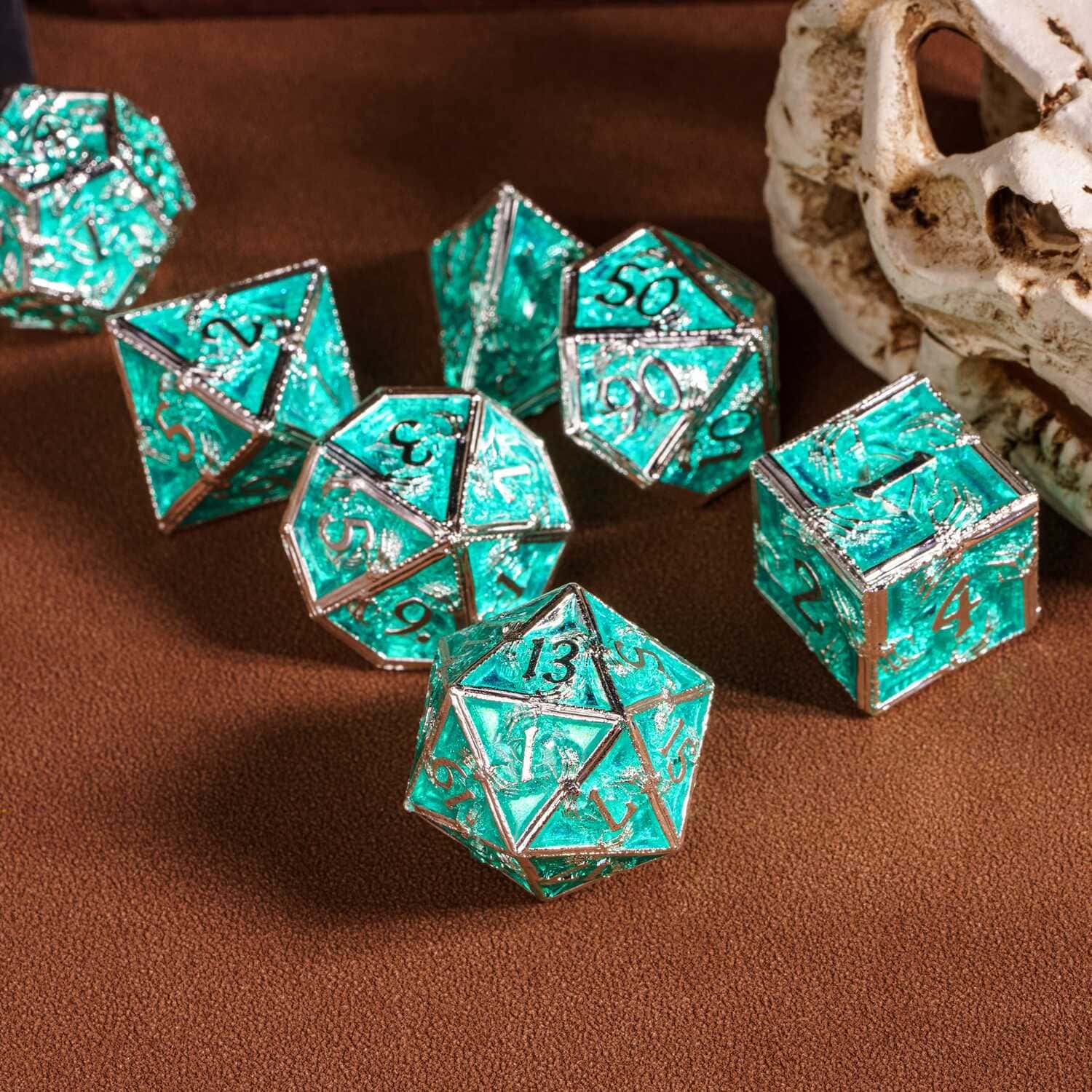 Flat lay Siren's Crypt Metal Dice Set teal with silver frame 7 piece dice collection