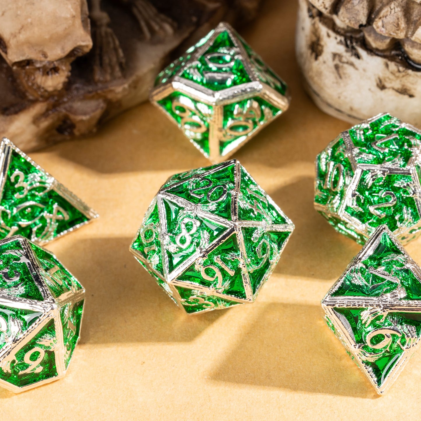 Siren's Crypt metal dice set displayed in skull prop with green panels and silver dragon frames