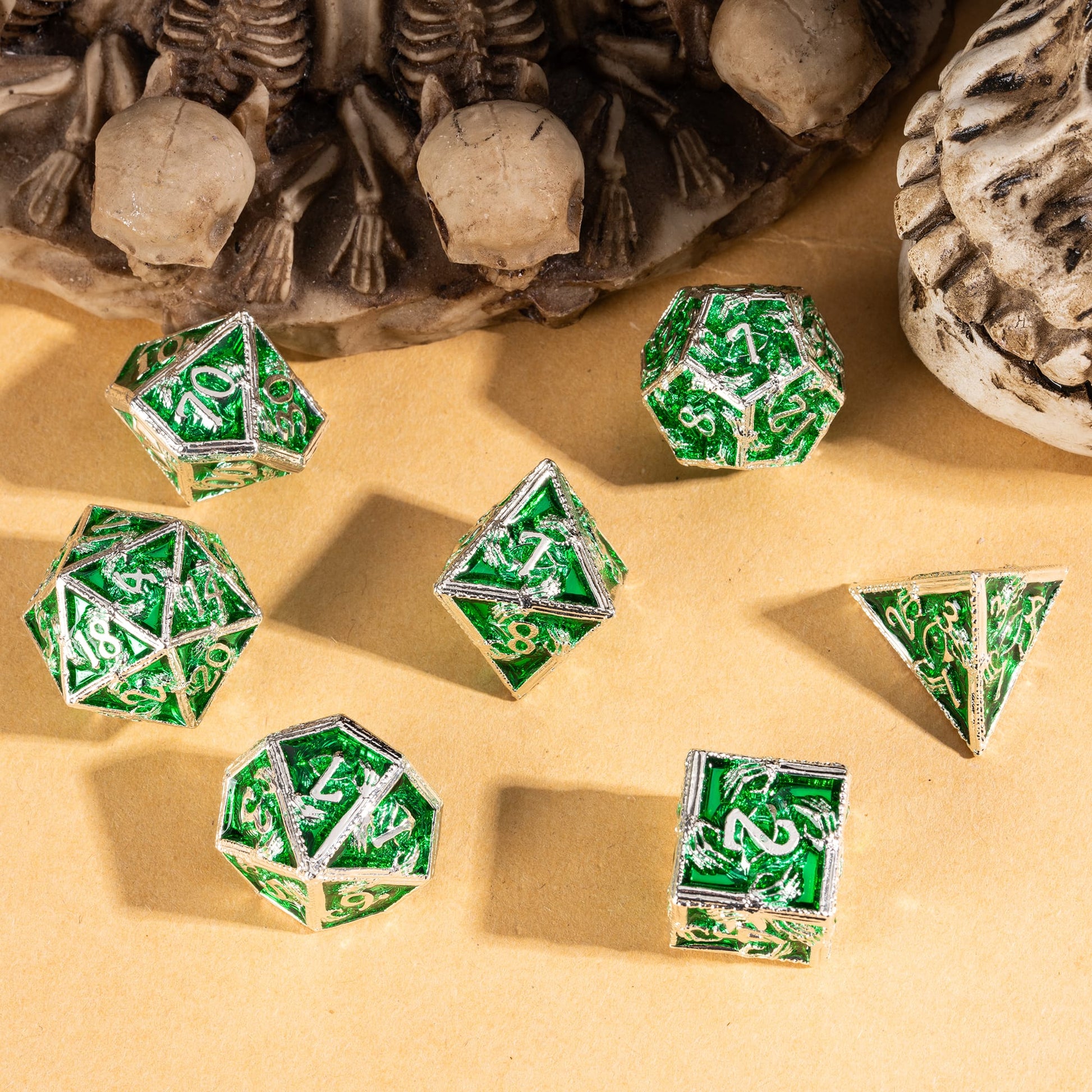 Siren's Crypt metal dice set arranged on sand with emerald green panels for tabletop RPGs