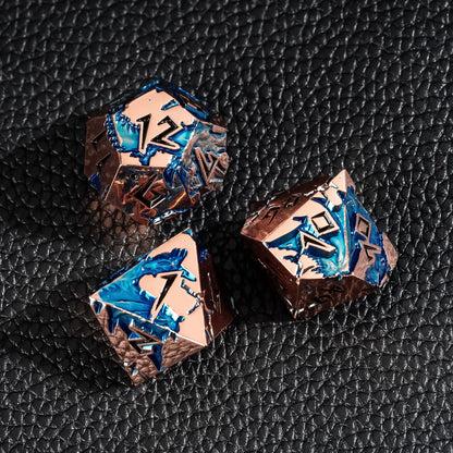 Close up of Stormwake Dragon metal dice showing blue inlay and engraved details